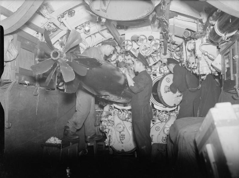O14 - Checking torpedo's
Regular checking up to keep torpedoes in running order is essential. The leading torpedo artificer is seen on the right at the rear door of the starboard upper tube on board the Dutch submarine O 14. O14 - Checking torpedo's